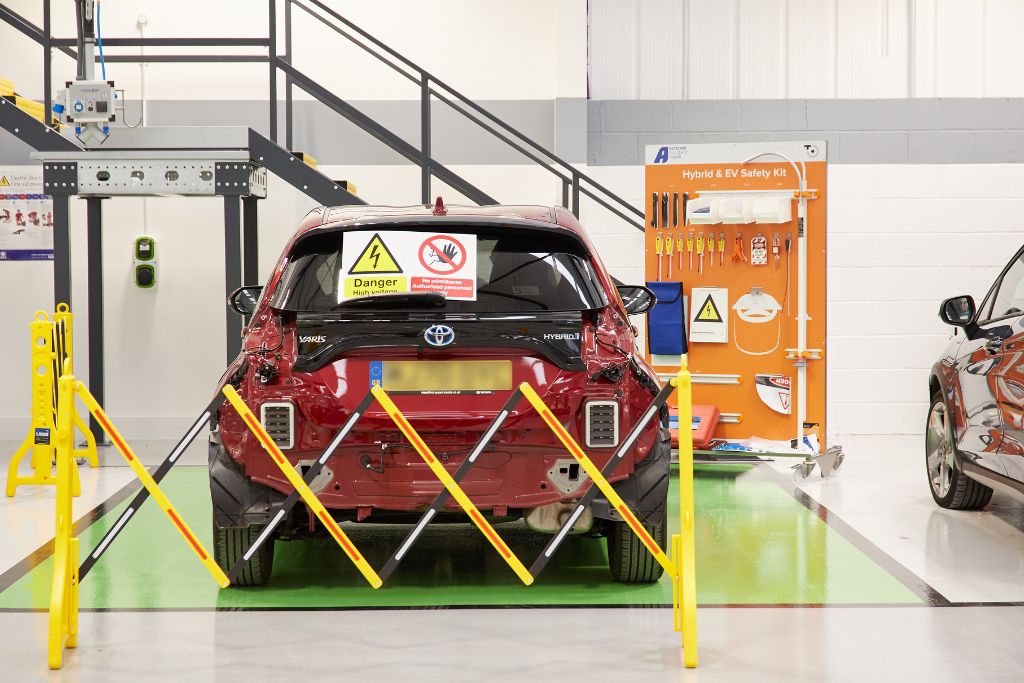 EV Repair Bay - Activate Accident Repair. Hybrid vehicle being repaired by electric vehicle specialists.